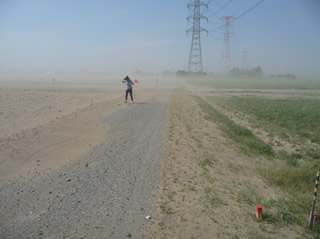 噴砂による砂嵐の中を調査する若松氏（2011年4月）